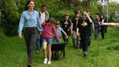 Prince Louis of Wales pushes a wheelbarrow as he follows his mother, Britain&#x27;s Catherine, Princess of Wales (L) and sister Britain&#x27;s Princess Charlotte of Wales while taking part in the Big Help Out, during a visit to the 3rd Upton Scouts Hut in Slough on May 8, 2023 