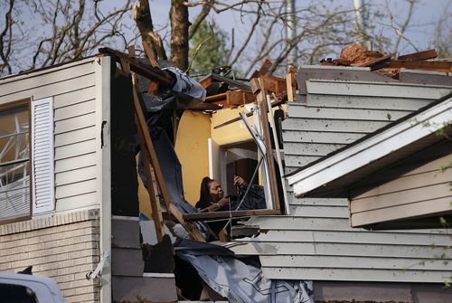 Une femme récupère les effets personnels d'un membre de la famille après que le toit a été arraché par une tornade sur Oakview Drive à North Little Rock, Ark. Vendredi 31 mars 2023.