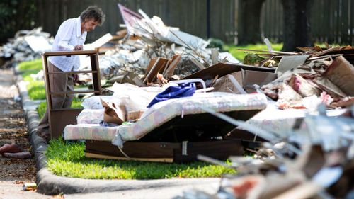 Resident Antoinette Porcarello views her flood-damaged possessions piled in the front yard in the aftermath of the hurricane. (AP)