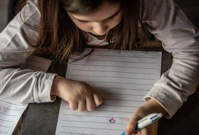 Young girl writing letter.