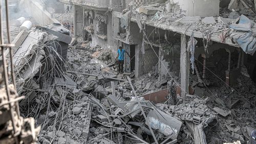 A man stands among the rubble of buildings destroyed in an Israeli bombing in central Gaza.