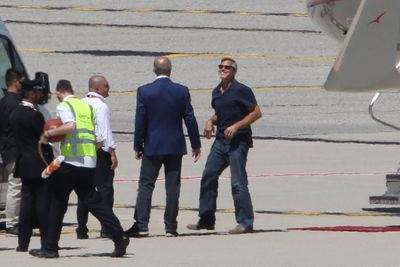The 56-year-old actor was in good spirits as he laughed with staff on the tarmac.