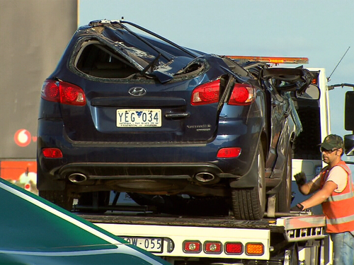 A woman has been taken to hospital after the overhead sign fell onto a car below.