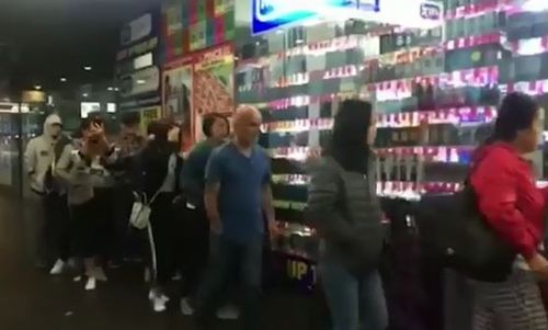 The shoppers are seen lining up outside the My Chemist store in Melbourne before regular opening hours. (Herald Sun)