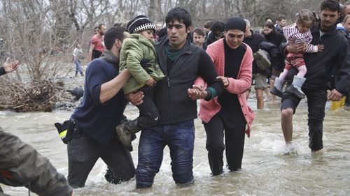 People died during the dangerous crossing, as families helped children and the elderly through the rushing waters. (AAP)