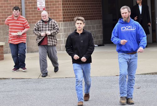 Parents escort their children out of the school after the shooting. (AAP)