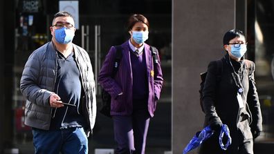 People wearing face masks walk through the city on July 20, 2020 in Melbourne, Australia. 