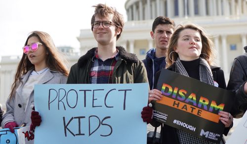 Protestors hold signs as they rall outside the US Capital on  March 3. (AAP)