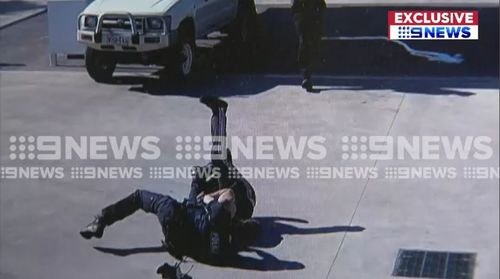 Officers then tackle the man to the ground at the Smithfield Plains petrol station, with one officer appearing to punch the man in the head.