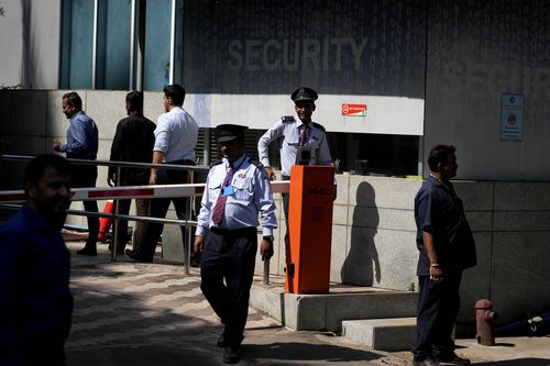 Private security guards stand outside a building housing BBC office, in Mumbai, India, Tuesday, Feb. 14, 2023. 