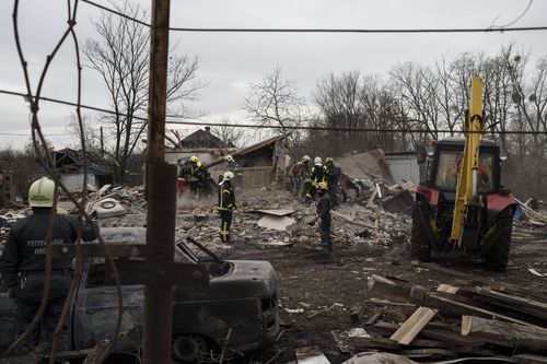 Emergency workers remove debris of a house destroyed following a Russian missile strike in Kyiv, Ukraine, Thursday, Dec. 29, 2022.