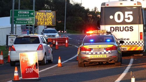 Motorists drive through the 'ring of steel' checkpoint set up by Victoria Police at the border of Sunbury and Gisborne South on the Calder Freeway this morning