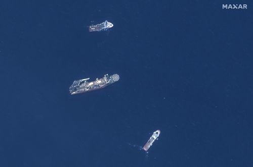 In this satellite image provided by Maxar Technologies, from top to bottom, the vessels Horizon Arctic, Deep Energy and Skandi Vinland search for the missing submersible Titan, Thursday, June 22, 2023 in the Atlantic Ocean.