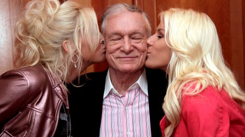 Hefner is kissed by his two girlfriends at the Hotel de Paris in Monaco, 21 February 2009.
