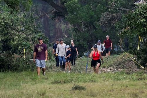 * People search the area in Hunt, Texas, on July 6.
