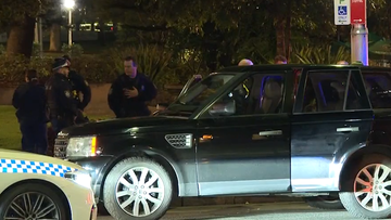 Police officers inspect the allegedly stolen vehicle after a high-speed pursuit through Sydney&#x27;s CBD.