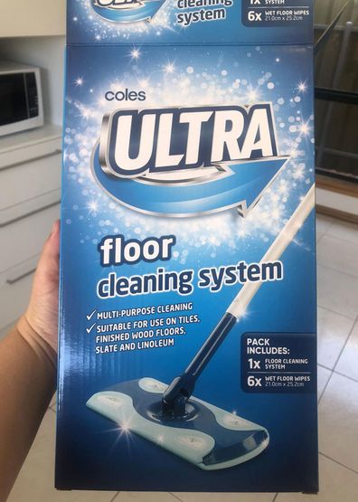 Woman holding the Coles Ultra floor cleaning system box in her hand