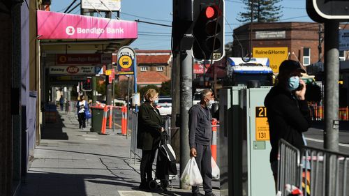 People walk past shops on Forrest Road in Bexley, Sydney. during the COVID-19 lockdown. 