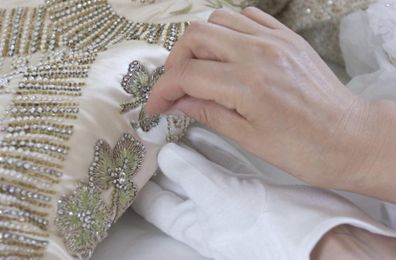 The Queen's Coronation dress of white satin is prepared, for the Summer Opening of Buckingham Palace's State Rooms by senior textile conservator Janet Woods at work in the Textile Conservation Studio at Hampton Court Palace in SW London. *    