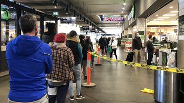 A long queue forms outside Woolworths supermarket in South Melbourne