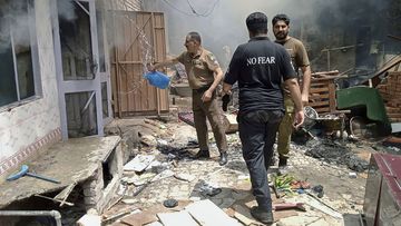 Police inspect a house that was set on fire in a Christian neighborhood in Jaranwala on Wednesday.