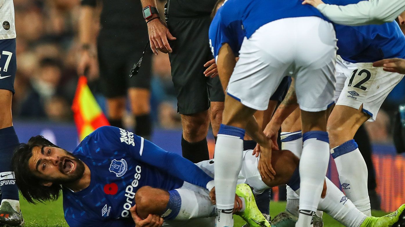 Andre Gomes of Everton reacts in pain after a tackle from Son Heung-min of Tottenham Hotspur 