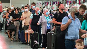 Airline passengers wait in line to check in at Sydney&#x27;s Kingsford Smith domestic airport