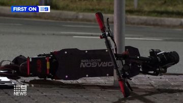An e-scooter driver is in a critical condition after running a red light into oncoming traffic and being hit by a car.