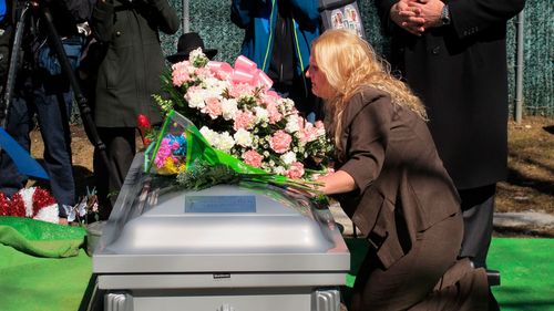 Mari Gilbert kneels over the coffin of her daughter Shannan Gilbert at Amityville Cemetery on March 12, 2015.