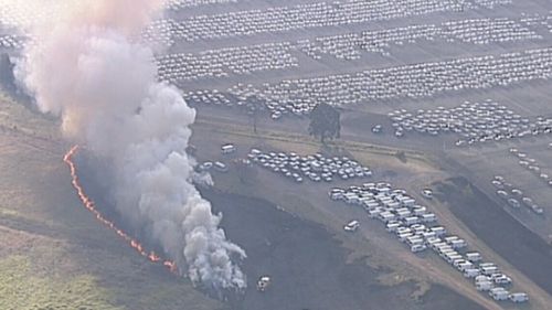 The fire threatened the car yard and the Odyssey House building. (9NEWS)