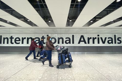 Des passagers marchent aux arrivées internationales de l'aéroport de Hearhtow, à Londres, le vendredi 26 novembre 2021. 