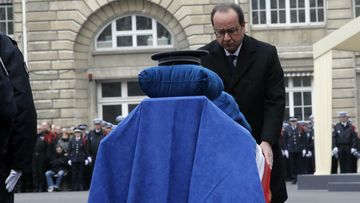 French President Francois Hollande leans over the coffin of late Police officer Ahmed Merabet. (AAP)
