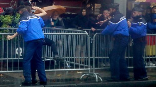 French police officers apprehend a topless protestor who ran toward the motorcade of President Donald Trump who was headed on the Champs Elysees to an Armistice Day Centennial Commemoration at the Arc de Triomphe.