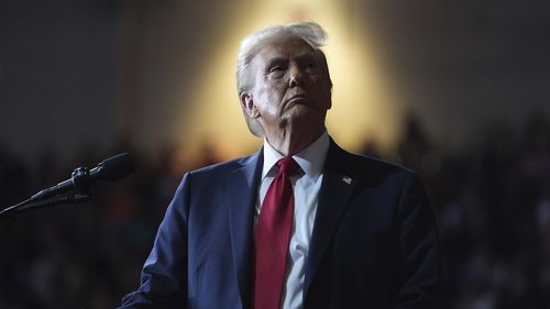 President Donald Trump watches a video screen at a campaign rally.