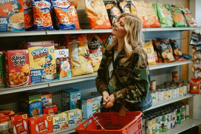 Woman shopping for drinks and snacks in a small convenience store in Los Angeles, California.