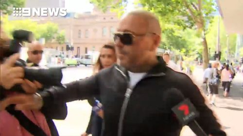 The moment the former bikie shoved photographer Ellen Smith outside court. (9News)