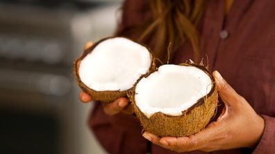 Image of Minoli De Silva's hands holding the cracked open coconut.