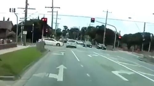 A white vehicle enters the traffic lights at the same time as the Focus and T-bones it. (YouTube)