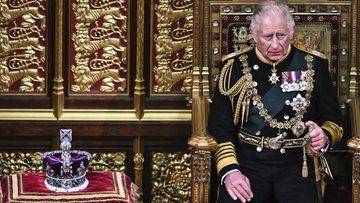 Prince Charles, Prince of Wales (R) sits by the The Imperial State Crown (L) in the House of Lords Chamber, during the State Opening of Parliament, in the Houses of Parliament, in London, on May 10, 2022