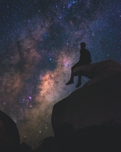 Man sits on a rock beneath night sky in Mid Murray region