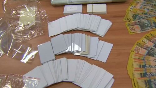 Police allegedly found thousands of dollars, mobile phones and equipment for forging IDs. (9NEWS)