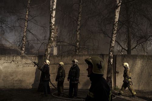 Firefighters extinguish a fire at a factory after a Russian attack in the outskirts of Kharkiv, Ukraine, Friday, April 15, 2022. (AP Photo/Felipe Dana)