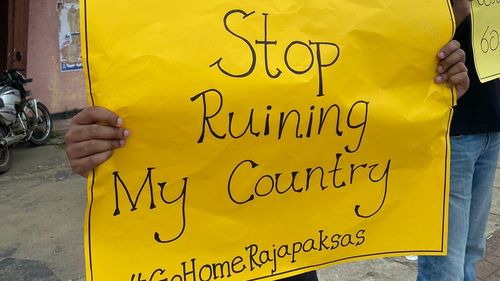 A protester in Sri Lanka's capital Colombo hold up a sign demanding the President 'stop ruining my country'. 