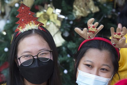 Women wearing masks to curb the spread of coronavirus, celebrate Christmas at a church in Bali, Indonesia on Friday, Dec. 24, 2021. 
