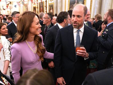 Catherine, Princess of Wales places a hand on her the Prince of Wales's back at a reception at Buckingham Palace to mark 100 years since the birth of Queen Elizabeth II on April 21, 2026.
