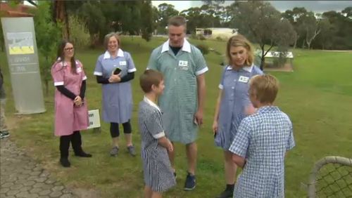 Principal Paul Luke (green dress) with students.