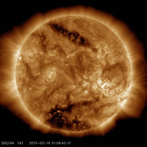 This image from NASA's Solar Dynamics Observatory on March 16, 2015, shows two dark spots, called coronal holes. The lower coronal hole, a polar coronal hole, was one of the biggest observed in decades.