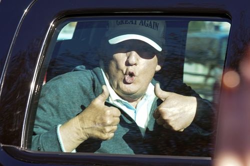President Donald Trump gives two thumbs up to supporters as he departs after playing golf at the Trump National Golf Club in Sterling, Virginia today.