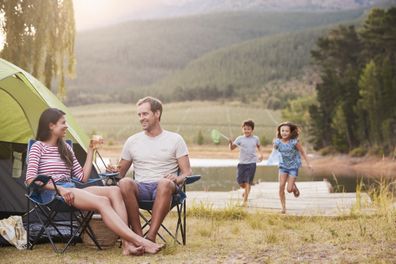 Parents enjoy a drink while camping with their kids