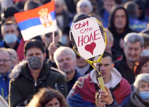 A supporter of Serbia's Novak Djokovic holds a banner that reads: ''We all are Nole (Novak)'' during protest in Belgrade, Serbia, Friday, Jan. 7, 2022. 